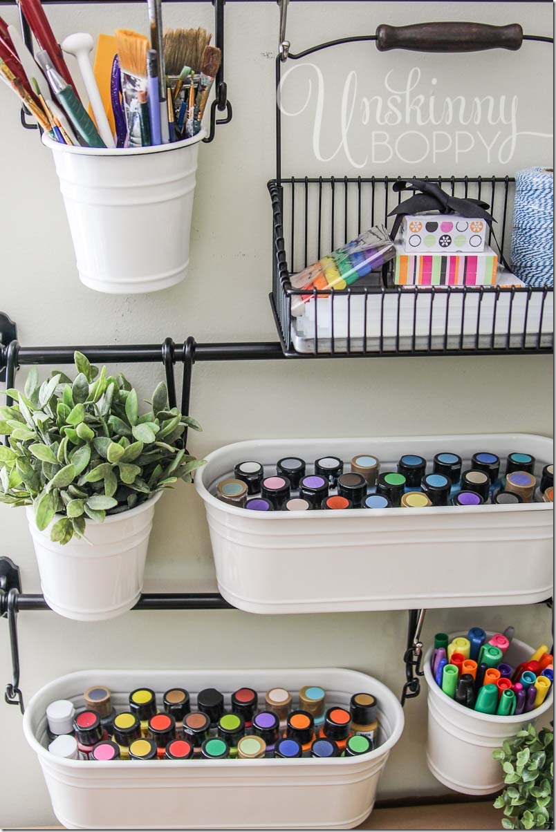 Store art supplies in hanging buckets from IKEA for easy craft room organization.